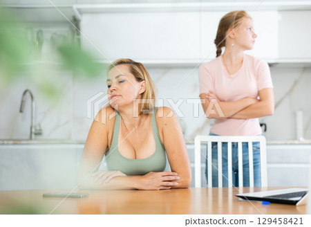 Quarreled mum and daughter do not talk ignore to each other and look in different directions. 129458421