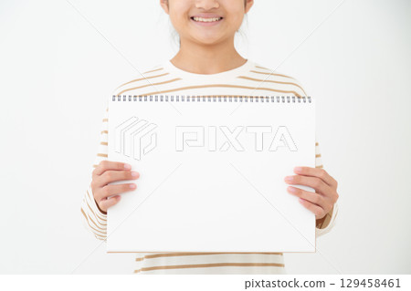 A smiling junior high school girl holding a sketchbook 129458461