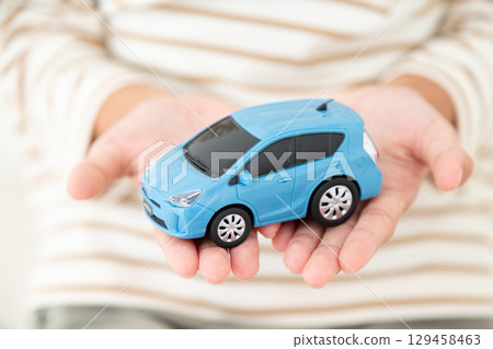 A middle school girl holding a model car 129458463