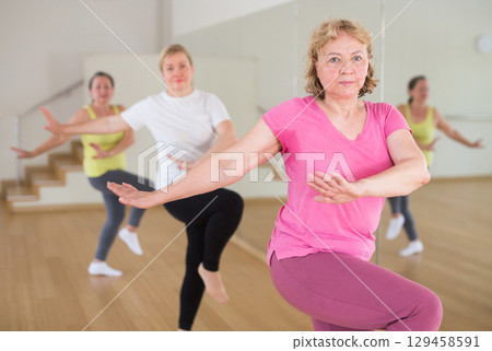 Adult people learning swing steps at dance class Adult people learning swing steps at dance class 129458591