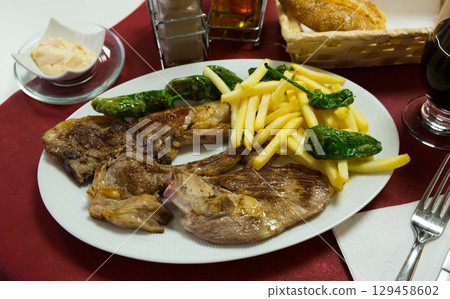 Tasty lamb chops baked and served with french fries and green pepper 129458602