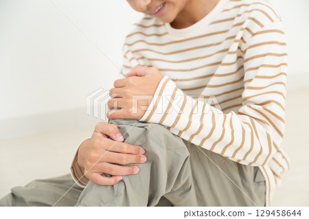 A middle school girl suffering from knee pain A middle school girl suffering from knee pain 129458644