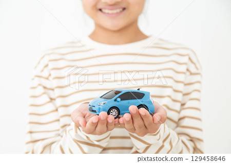一名國中女生微笑地抱著模型車 一名國中女生微笑地抱著模型車 129458646