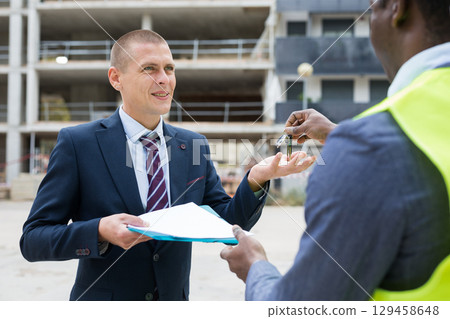 Happy businessman gets the keys to new shopping center 129458648