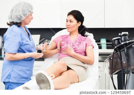 Woman consulting with cosmetologist about breast augmentation procedures Woman consulting with cosmetologist about breast augmentation procedures 129458697