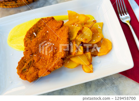 Breaded pork with potato and mustard sauce 129458700
