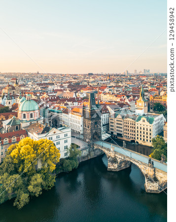 Stunning aerial view captures Charles Bridge and the Old Town Bridge Tower at sunrise, surrounded by the beautiful architecture of Prague along the Vltava River. Stunning aerial view captures Charles Bridge and the Old Town Bridge Tower at sunrise, surrounded by the beautiful architecture of Prague along the Vltava River. 129458942