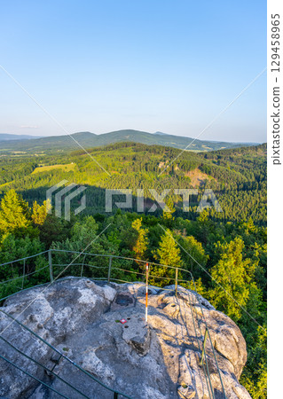 Witness the breathtaking sunset over Jested Ridge as viewed from the Popov Cliffs in the Lusatian Mountains, featuring lush green forests and striking sandstone formations during evening. Witness the breathtaking sunset over Jested Ridge as viewed from the Popov Cliffs in the Lusatian Mountains, featuring lush green forests and striking sandstone formations during evening. 129458965
