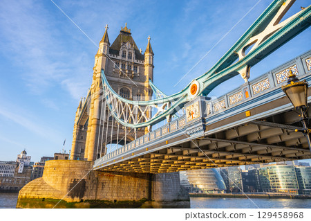 Early morning sunlight illuminates Tower Bridge, creating a stunning view over the Thames River. The iconic structure blends history with the vibrant atmosphere of London. Early morning sunlight illuminates Tower Bridge, creating a stunning view over the Thames River. The iconic structure blends history with the vibrant atmosphere of London. 129458968