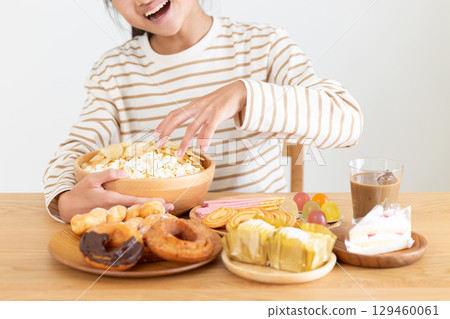 A middle school girl eating a lot of sweets 129460061