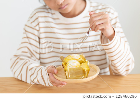 A middle school girl is worried in front of a Mont Blanc cake in her room 129460280