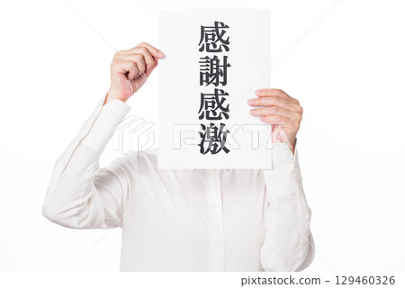A person wearing a white shirt holding a piece of paper that says "Thank you" A person wearing a white shirt holding a piece of paper that says "Thank you" 129460326