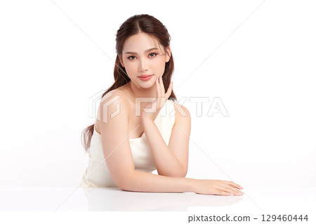 A beautiful young Asian woman with clean, fresh skin against a white background. Skincare, facial treatment, cosmetology, beauty, and spa. An elegant portrait of an Asian woman. 129460444