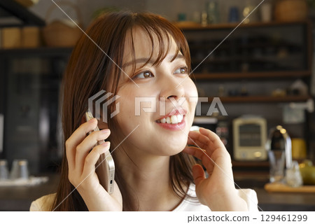 打電話的一名微笑的婦女在她的智能手機 打電話的一名微笑的婦女在她的智能手機 129461299