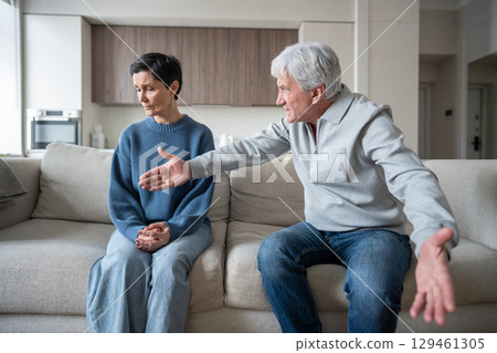 Older wife enduring verbal aggression from hysterical partner in toxic domestic struggle dependency 129461305