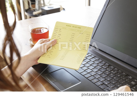 A woman managing her bank transaction history on a PC 129461546