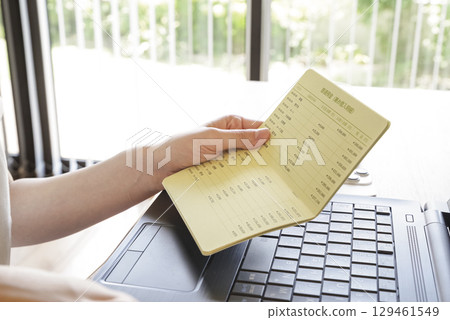 A woman managing her bank transaction history on a PC 129461549
