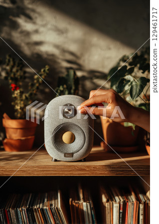 Hand using portable sound speaker 129461717