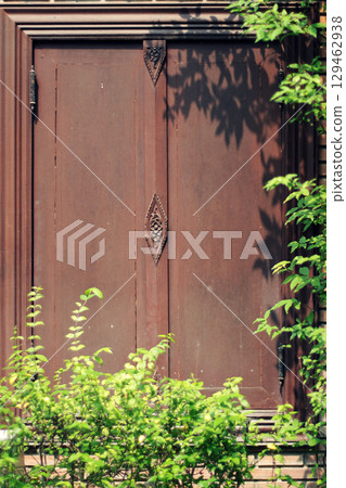 Tree shadows in the garden on antique thai style wooden window on brick wall. Vintage concept. Tree shadows in the garden on antique thai style wooden window on brick wall. Vintage concept. 129462938