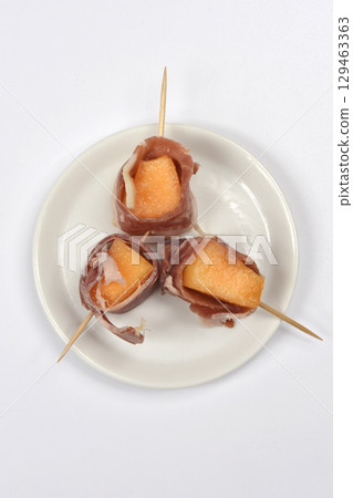 Cubes of melon wrapped in prosciutto Cubes of melon wrapped in prosciutto 129463363