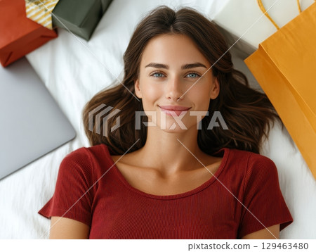 Elegant Woman On White Bed With Brown Shopping Bag 129463480