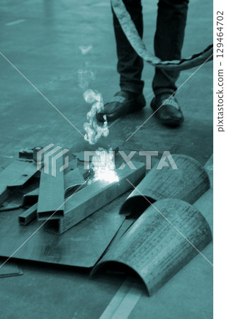 Person cleaning metal surface from rust with laser. Laser cleaning metal surfaces. Laser cleaning metal from rust. Glowing laser beam cleansing metal. Glowing beam removes removing old dirt metallic 129464702