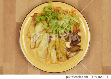 Potato wedges and small stuffed squids 129465191