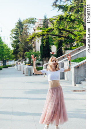 woman in dress dancing to music outdoors woman in dress dancing to music outdoors 129465313