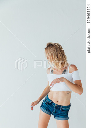 Slim blonde dancing to music in white room Slim blonde dancing to music in white room 129465324