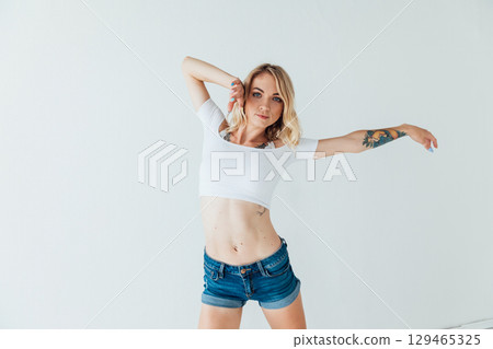 Slim blonde dancing to music in white room Slim blonde dancing to music in white room 129465325