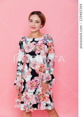 woman in summer dress with flowers on pink background 129465364