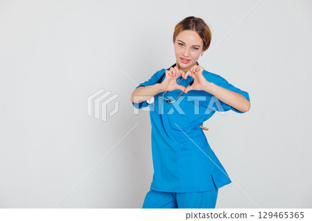 Woman doctor with stethoscope showing heart 129465365