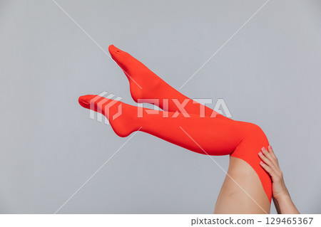 female legs in red tights stockings on a white background 129465367