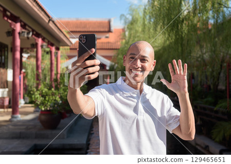 Modern man in Zen garden using smartphone, blending nature and technology Modern man in Zen garden using smartphone, blending nature and technology 129465651