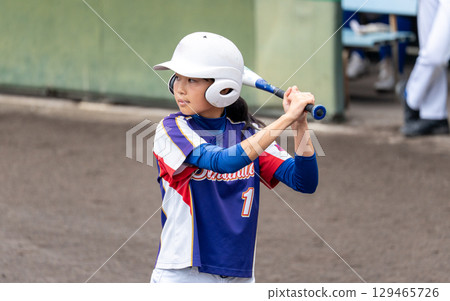 一名國中女生在俱樂部活動中擊打壘球 129465726