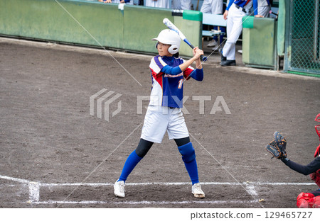 A junior high school girl batting softball in a club activity 129465727