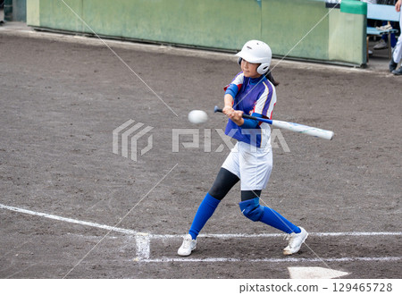 A junior high school girl batting softball in a club activity 129465728