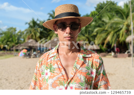 Hispanic Male Tourist in Panama Hat and Tropical Shirt Enjoying Summer Vacation at Beach 129465739