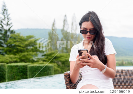 Asian woman in white polo shirt near swimming pool, outdoor nature, summer holiday portrait Asian woman in white polo shirt near swimming pool, outdoor nature, summer holiday portrait 129466049