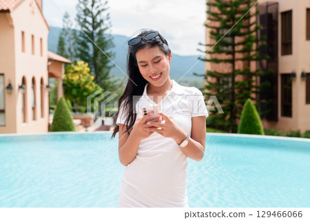 Asian woman in white polo shirt near swimming pool, outdoor nature, summer holiday portrait Asian woman in white polo shirt near swimming pool, outdoor nature, summer holiday portrait 129466066