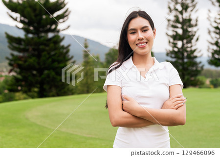 Asian woman in white polo shirt at golf course, on greenery field, tourist outdoor lifestyle 129466096