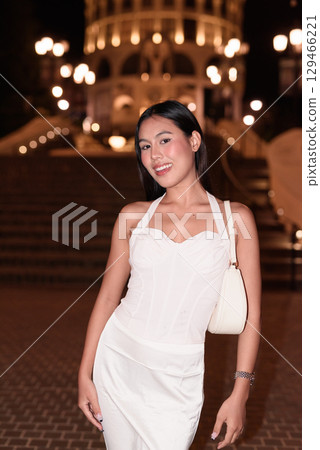 Young Asian woman tourist with long black hair in European style town at night 129466221