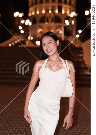 Young Asian woman tourist with long black hair in European style town at night 129466222