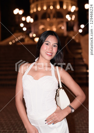 Young Asian woman tourist with long black hair in European style town at night Young Asian woman tourist with long black hair in European style town at night 129466224