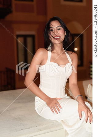 Young Asian woman tourist with long black hair in European style town at night Young Asian woman tourist with long black hair in European style town at night 129466241