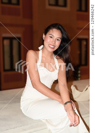 Young Asian woman tourist with long black hair in European style town at night Young Asian woman tourist with long black hair in European style town at night 129466242