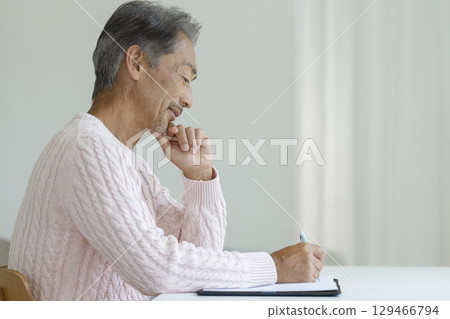 一位老人用筆寫字的側面像 一位老人用筆寫字的側面像 129466794