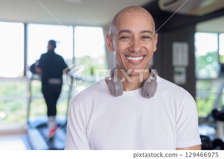 Confident bald Hispanic man posing in gym, fitness and strength-focused lifestyle portrait Confident bald Hispanic man posing in gym, fitness and strength-focused lifestyle portrait 129466975