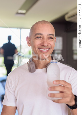 Man in gym drinking water after workout, fitness hydration and healthy lifestyle wellness concept Man in gym drinking water after workout, fitness hydration and healthy lifestyle wellness concept 129466981