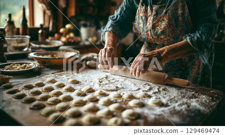 Homemade pasta preparation by a woman in traditional Italian style in a cozy kitchen setting 129469474